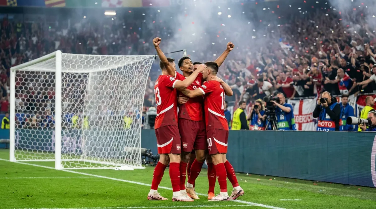 Jugadores de una selección de fútbol celebrando un gol abrazados junto a la portería durante un partido internacional